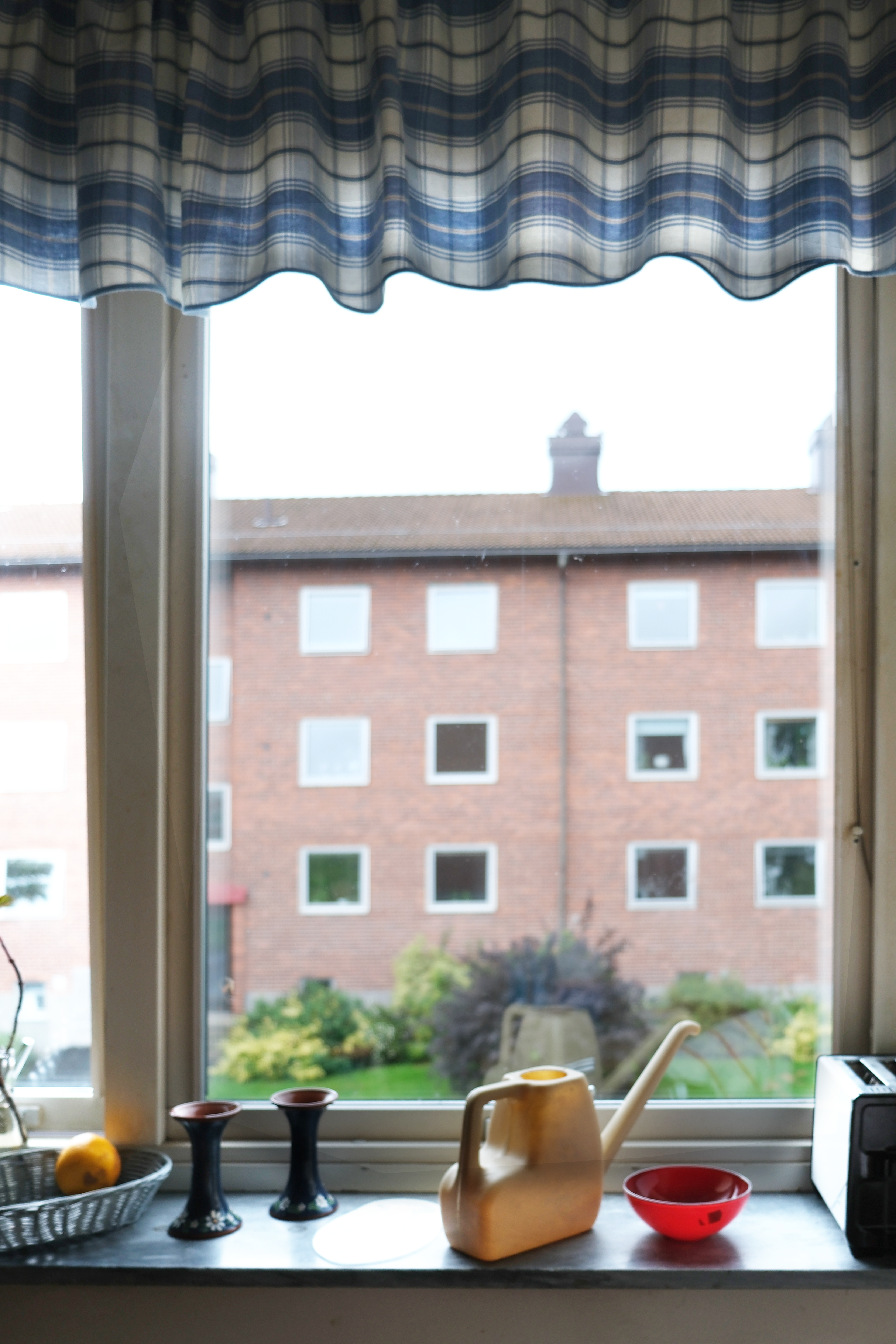 ett fönster som visar grannens hus