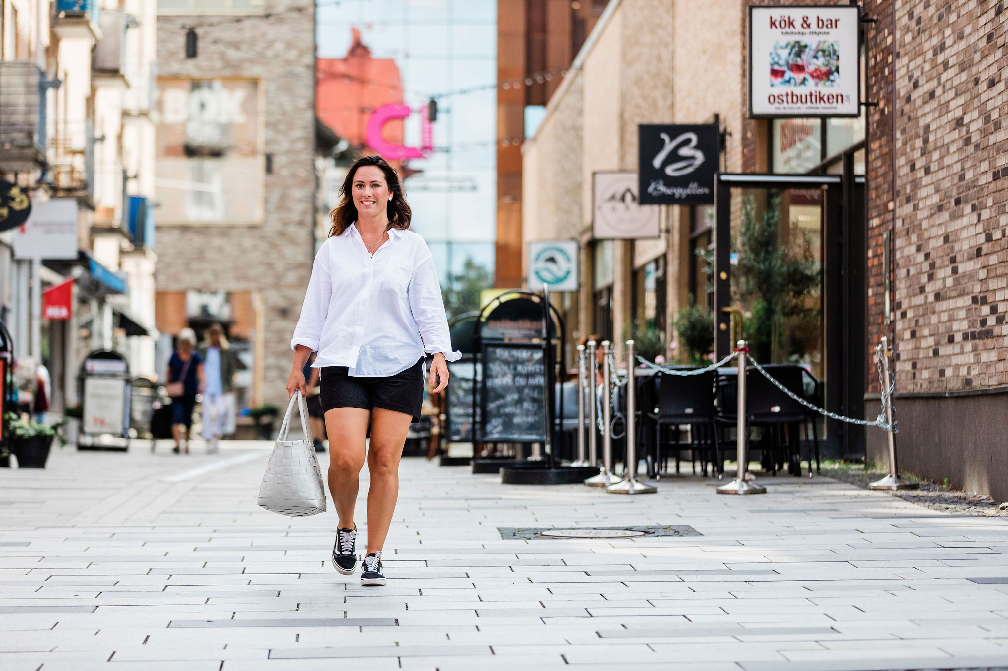 Kvinna promenerar på en gata i Mölndals innerstad.