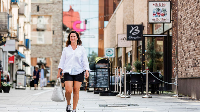 Kvinna promenerar på en gata i Mölndals innerstad.