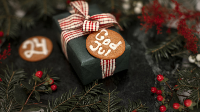 En liten julklapp inslagen i grönt papper och med en rutig tygrosett på. 